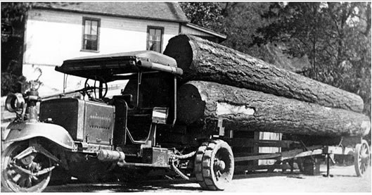 Early log truck with single steer tire, chain drive and wooden trailer around 1918 (University of Washington Libraries, Special Collections, UW8462).